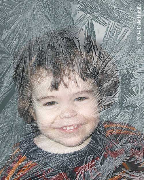 Boy looking through a frosty window